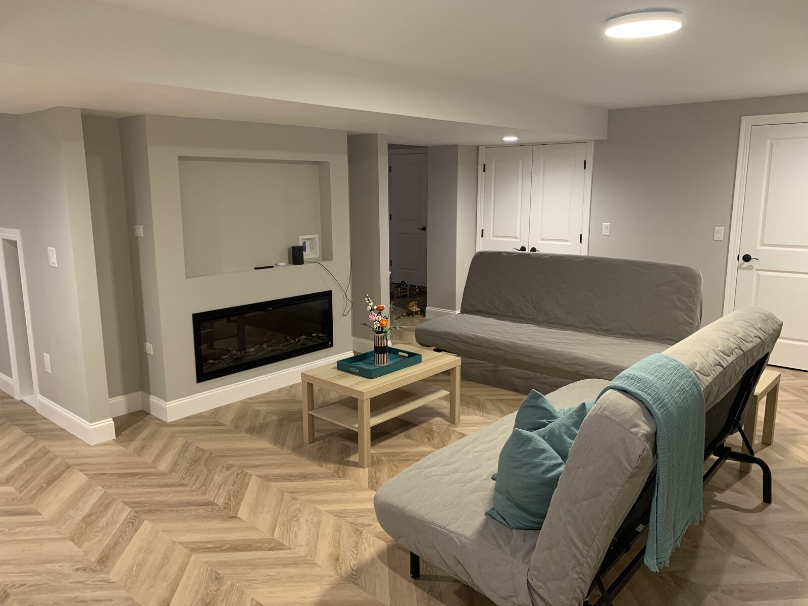 Finished basement family room with recessed fireplace and seating