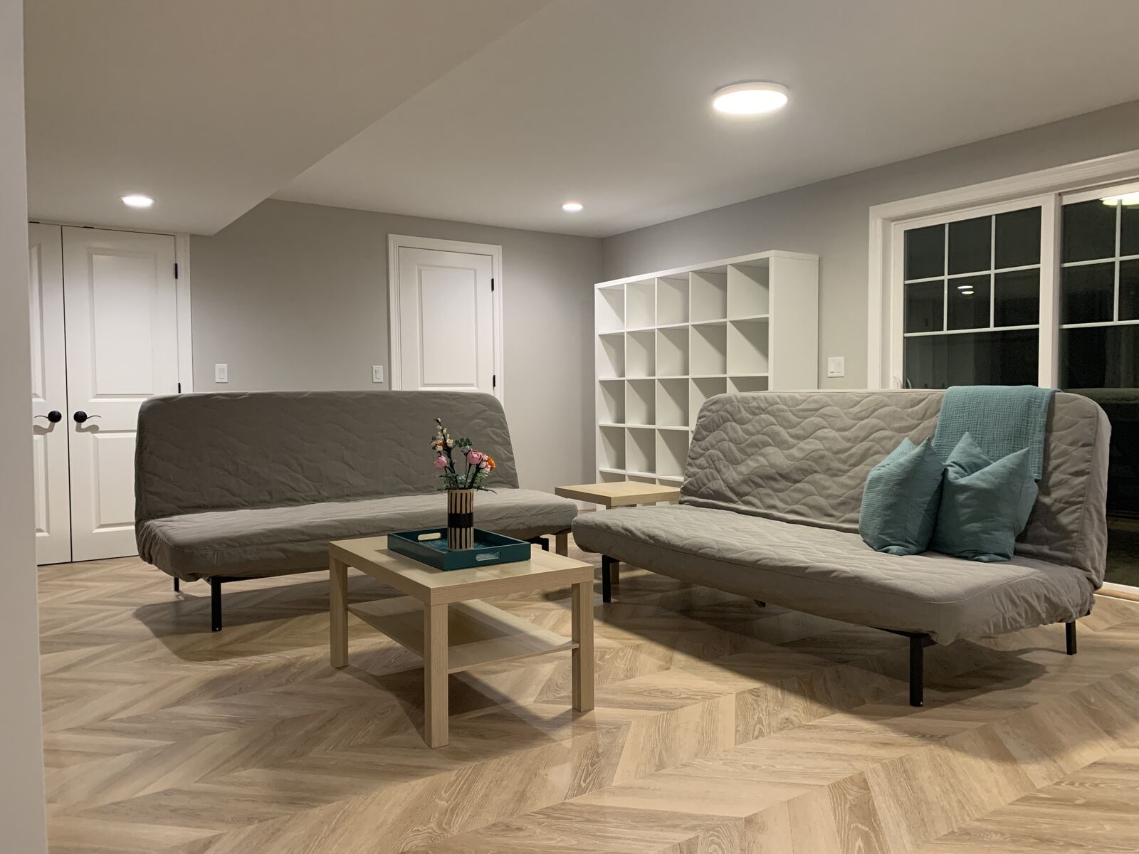 Finished basement room with herringbone-pattern flooring